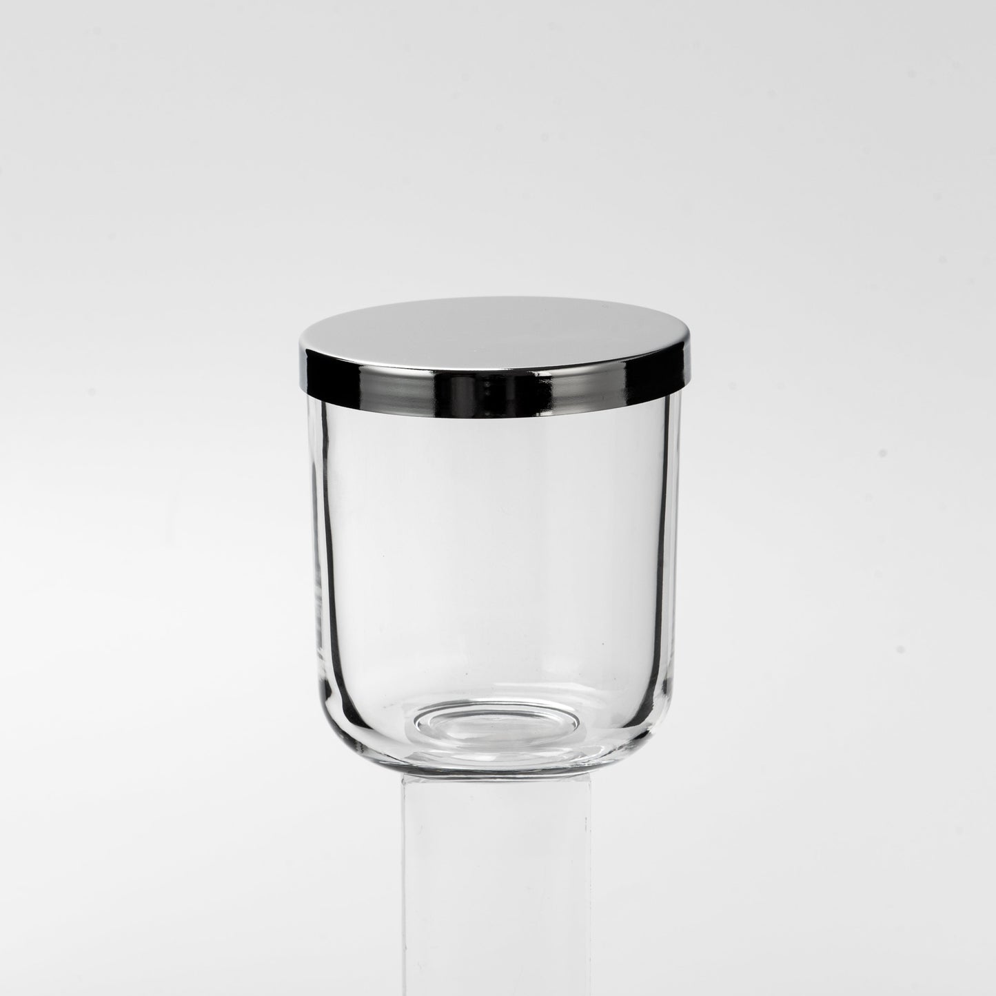 Clear glass container with black lid on a white background