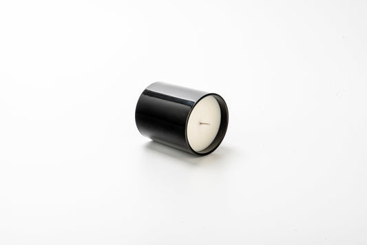 Black cylindrical candle on a white background