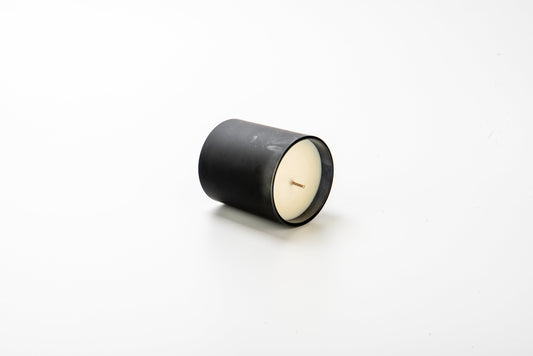 Black candle with white wax on a white background