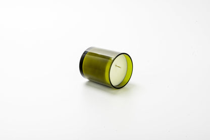 Green candle in a glass container on a white background