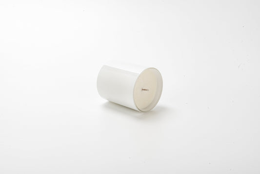White cylindrical candle on a white background