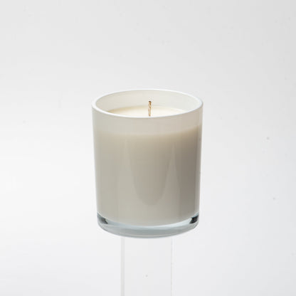 White candle in a glass holder on a white background