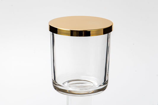 Clear glass jar with a gold lid on a white background